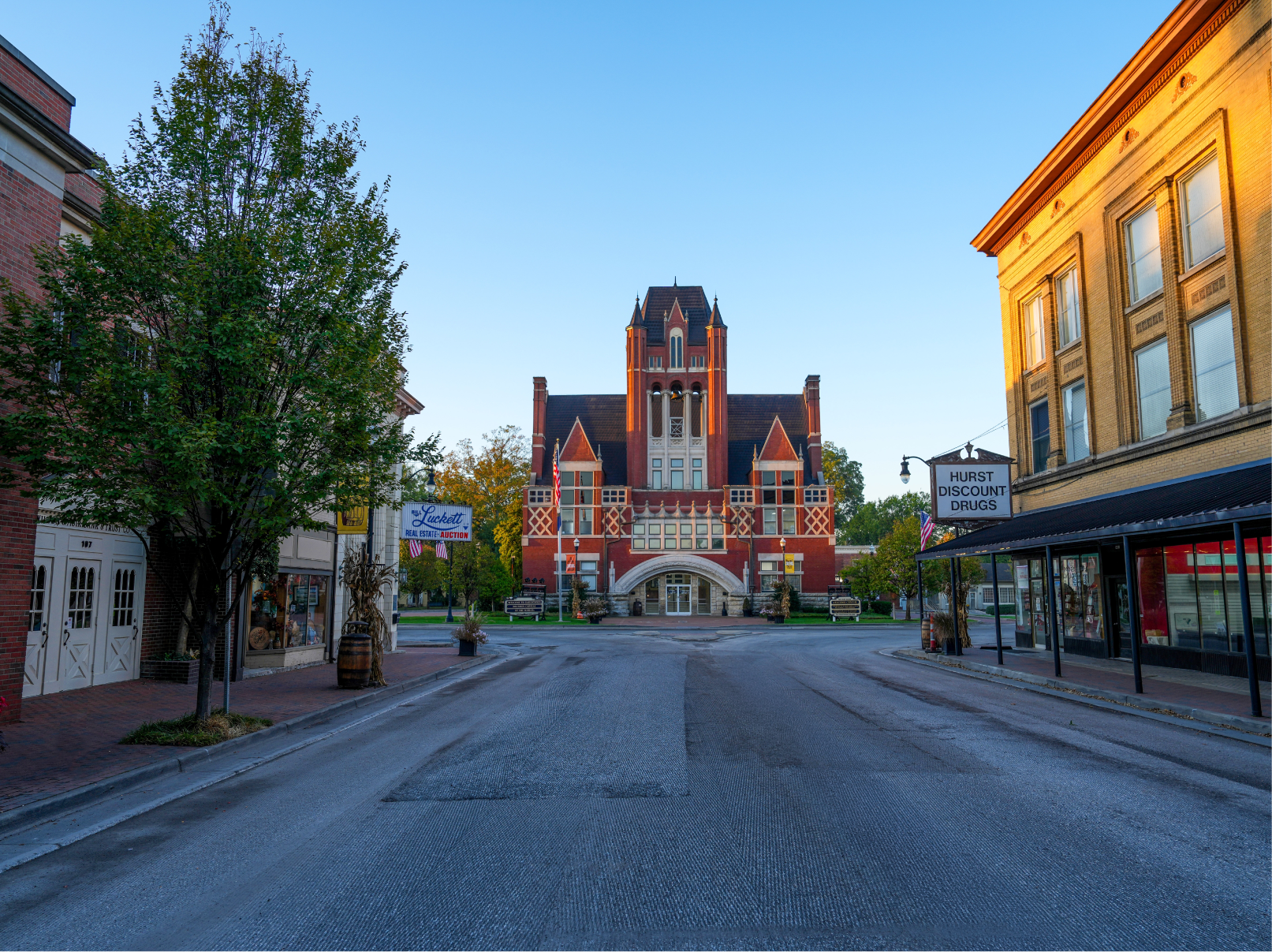 Downtown Bardstown, Kentucky street view with historic buildings and a large red-brick courthouse at sunrise