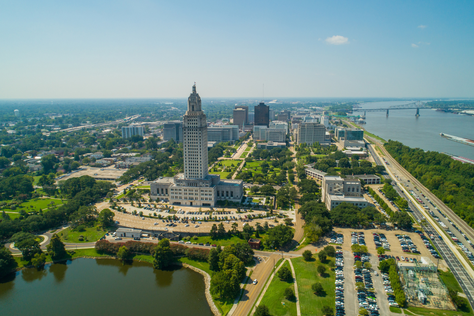 Aerial view of downtown Baton Rouge, Louisiana, featuring the Louisiana State Capitol and the Mississippi River.