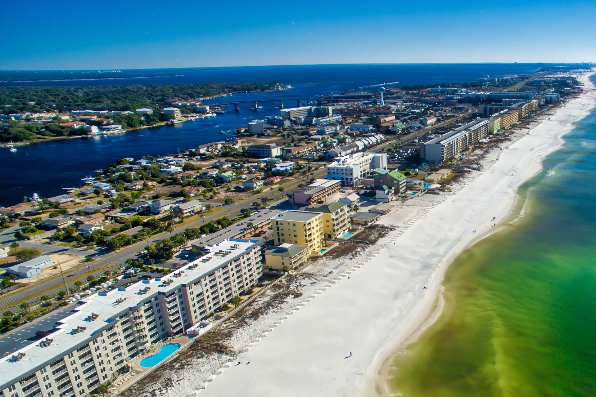 Aerial view of Mary Esther, Florida coastline, showing white-sand beaches, beachfront condominiums, and coastal waterways along the Gulf Coast.