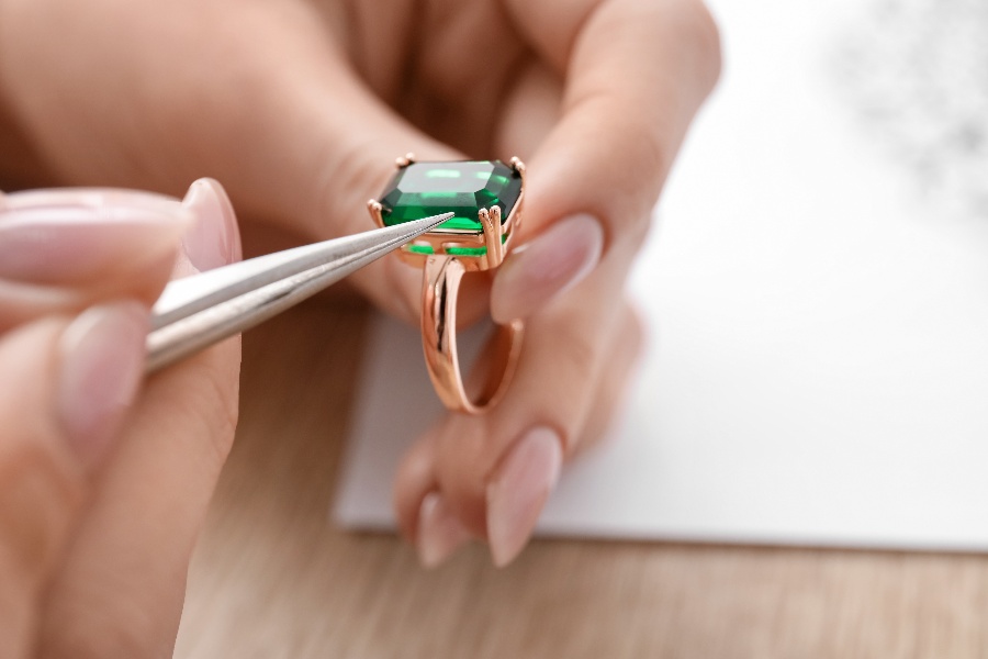 Jeweler looking at expensive ring with large jewel Jeweler looking at expensive ring with large jewel